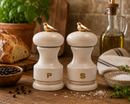 Bisetti Bird salt and pepper shakers with bird finials on a wooden surface with bread and herbs.