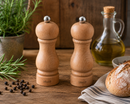 Bisetti sorrento salt and pepper mills on a wooden table with bread, oil, and herbs.